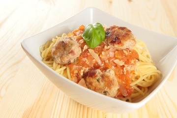spaghetti with basil garnish and meatballs