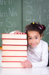 mädchen schaut hinter bücherstapel hervor