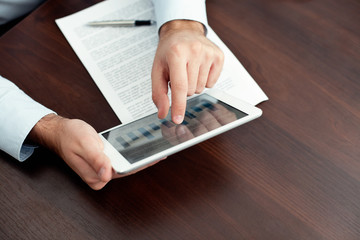 Businessman using digital tablet by the desk