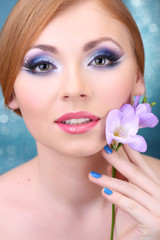 Fototapeta premium Beautiful young woman with glamour make up and flower