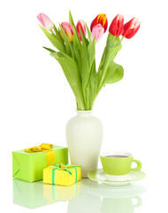 Beautiful tulips in bucket with gifts and cup of tea isolated