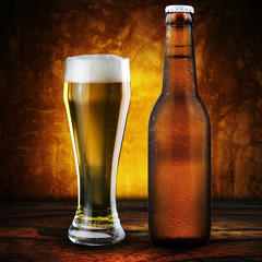 Bottle and glass of beer on wood table