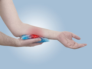 Female holding ice gel pack on hrting hand.