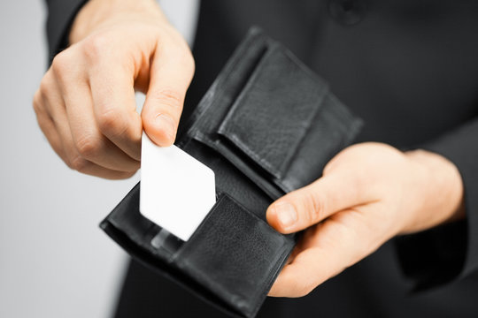 man in suit holding credit card