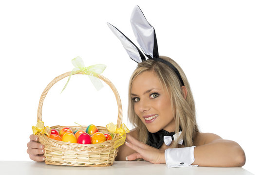 Frau mit Osterhasenohren und Eierkorb l&auml;chelnd