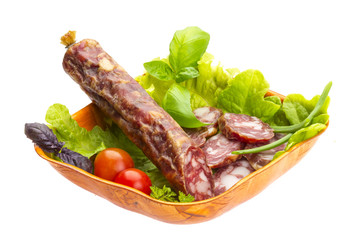Ripe salami with salad, basil, onion and tomato