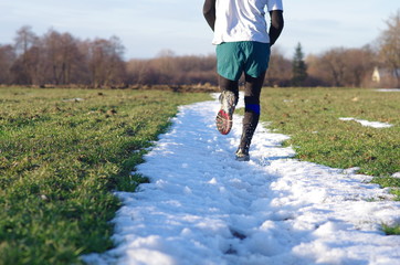 Mężczyzna biegający po pasie śniegu - obrazy, fototapety, plakaty