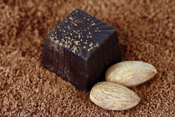 Chocolate sweets with cocoa, on brown background