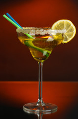 Yellow cocktail in glass on color background