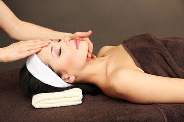Beautiful young woman in spa salon taking head massage,