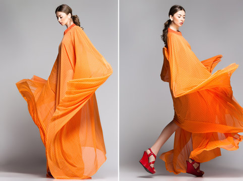 beautiful woman in long orange dress posing in the studio