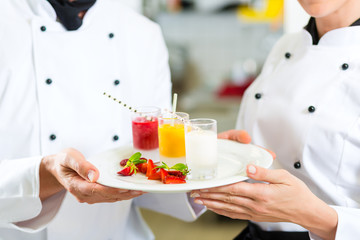 Chef team in restaurant kitchen with dessert