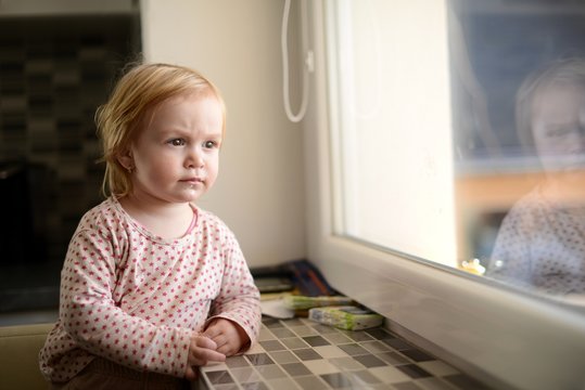 la jeune fille regarde par la fen&ecirc;tre