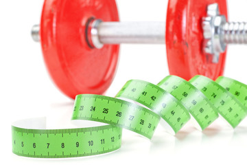 Green measuring meter and dumbbells for fitness. On a white back