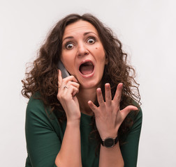 Curly shocked brunette talking on a phone