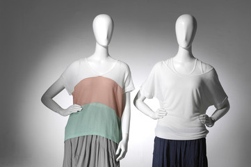 Fashion female clothes on two mannequin in light background