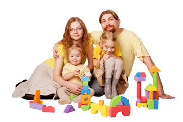 Happy redhead father, mother and two children building from toy