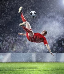 Tuinposter voetballer die de bal slaat © Sergey Nivens