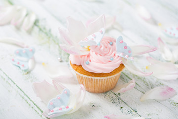 Cupcake mit rosa Buttercreme und Zuckerschmetterlingen