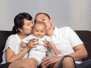 Fototapeta na wymiar mom and dad kiss baby
