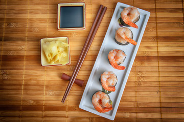 dish with fresh sushi rolls on bamboo napkin background