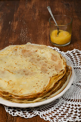 pancakes with lemon jam on plate on wooden table