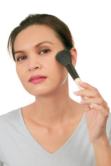 Isolated middle age asian woman with make up brush.