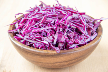 Shredded red cabbage in wooden bowl