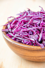 Shredded red cabbage in wooden bowl