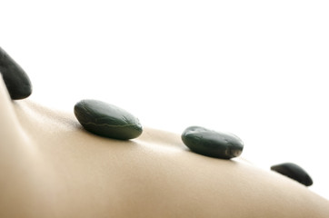 Side view of massage stones on the back of a woman