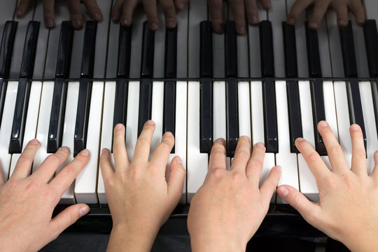 Quatre mains jouant du piano