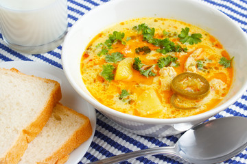 Warm chicken soup with bread slices and milk