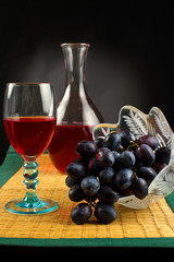Grapes with glass of red wine and carafe