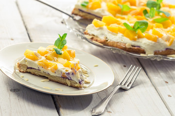 Cake with cream and peaches on a plate