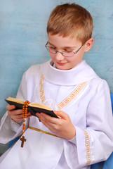 boy going to the first holy communion with prayer book