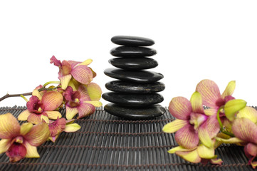Fototapeta na wymiar Branch orchid laying on mat with stones tower