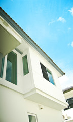 Modern white building with balcony on a blue sky