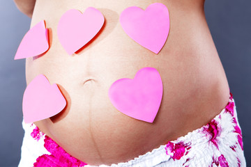 Pregnant women with notepaper on her belly