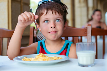 Cute little boy having delicious breakfast