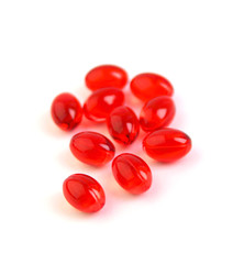 Red vitamin pills on white background