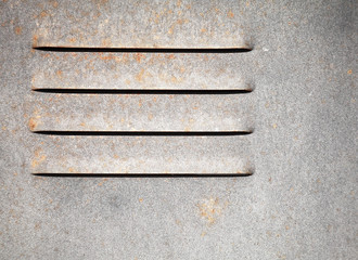 Fragment of an old gray metal wall with ventilation