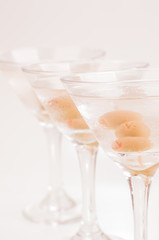 Three Dry Martini Cocktails over light purple background