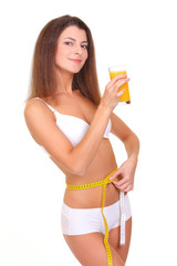 Beautiful sporty woman with measure and glass of orange juice