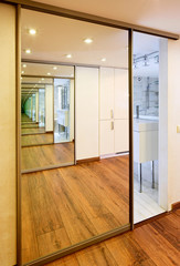 Sliding-door mirror wardrobe in modern hall interior with infini