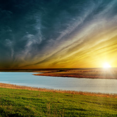 Fototapeta na wymiar dramatic sunset over river