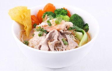 Laksa noodle soup with chicken, fresh vegetables and wonton