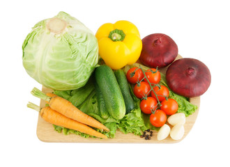 Vegetables on wooden cutting board isolated on white