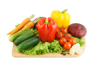 Vegetables on wooden cutting board isolated on white