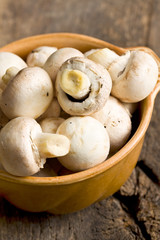 Champignon mushrooms in ceramic bowl.