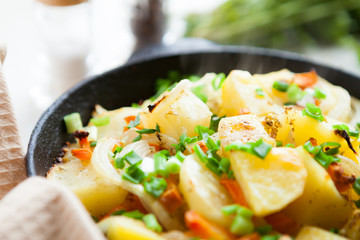 golden pieces of fried potatoes with greens